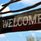 style billboard sign. the board at the top of the gate hangs on ropes. ranch entry to yard. Apache museum in nature. tassels